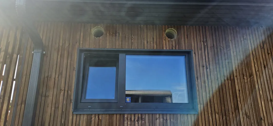 Ventilācijas caurumi koka apdares fasādē virs loga